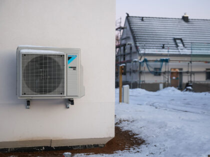 13 December 2022, Saxony, Leipzig: An air-source heat pump hangs on a house wall in snow and ice in a newly developing single-family housing area. During the night, temperatures in Leipzig dropped to minus 9 degrees under clear skies. Photo: Jan Woitas/dpa (Photo by Jan Woitas/picture alliance via Getty Images)