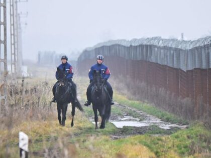 Hungarian border police officiers patrol on horses on December 15, 2022 at the Hungarian-Serbian border, close to Kelebia village. - In August 2022, the Hungarian government decided to strengthen the already existing 165-kilometer security border fence and build a new border protection system at the south part of the border. …