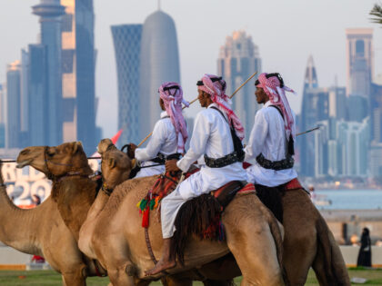 15 December 2022, Qatar, Doha: Mounted security forces ride their camels along the Corniche beach promenade, in the background the skyline with the modern skyscrapers can be seen. With the final Argentina against France ends on 18.12.2022 the World Cup 2022. Photo: Robert Michael/dpa (Photo by Robert Michael/picture alliance via …