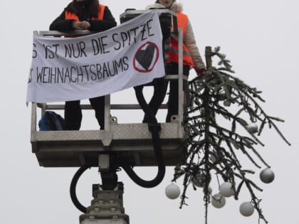 21 December 2022, Berlin: "It's just the top of the Christmas tree" is written on the banner of the activists of the "Last Generation". Two activists of the environmental group drove a lift truck in front of the Christmas tree on Pariser Platz at the Brandenburg Gate. They unfurled a …