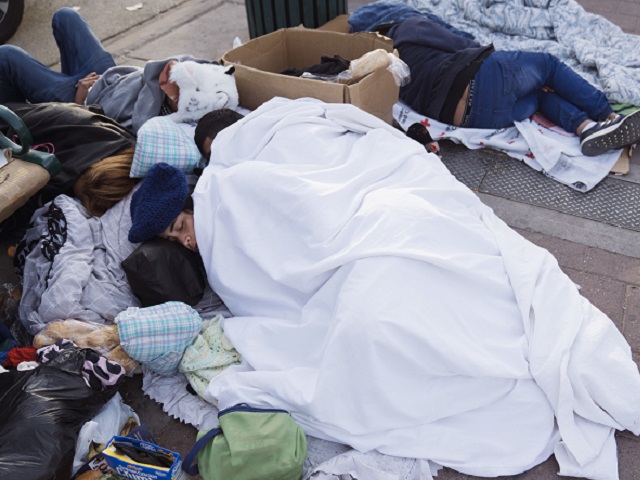 Migrants sleep outside the Greyhound bus station near the US and Mexico border in El Paso, Texas, US, on Tuesday, Dec. 20, 2022. Chief Justice John Roberts temporarily blocked the scheduled ending of pandemic-era border restrictions while the US Supreme Court considers a bid by Republican state officials to keep the rules in place during a legal fight. Photographer: Eric Thayer/Bloomberg via Getty Images