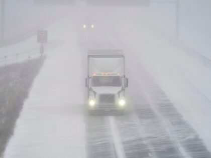 A transport truck drives along Highway 401 in London, Ontario, Canada, during a large winter storm on Friday, December 23, 2022. - Schools and some highways in the region were closed, and air travel was disrupted as the system made its way across the province. (Photo by Geoff Robins / …
