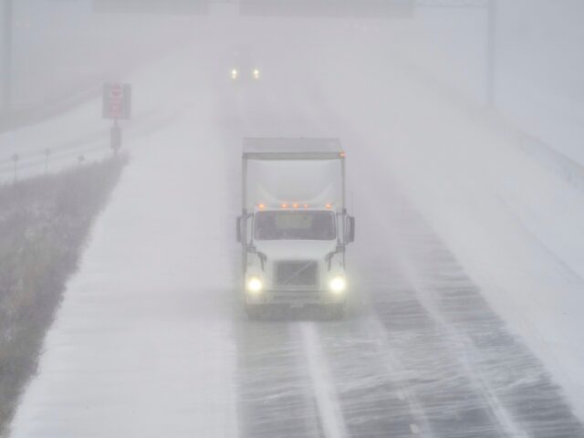 A transport truck drives along Highway 401 in London, Ontario, Canada, during a large wint
