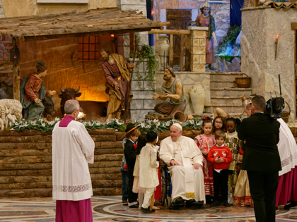 Pope Francis pay a visit to the Presepe with a group of child to bring it baby jesus statue at the end of Christmas Mass in Vatican, Saturday Dec. 24, 2022. (Photo by Massimo Valicchia/NurPhoto via Getty Images)
