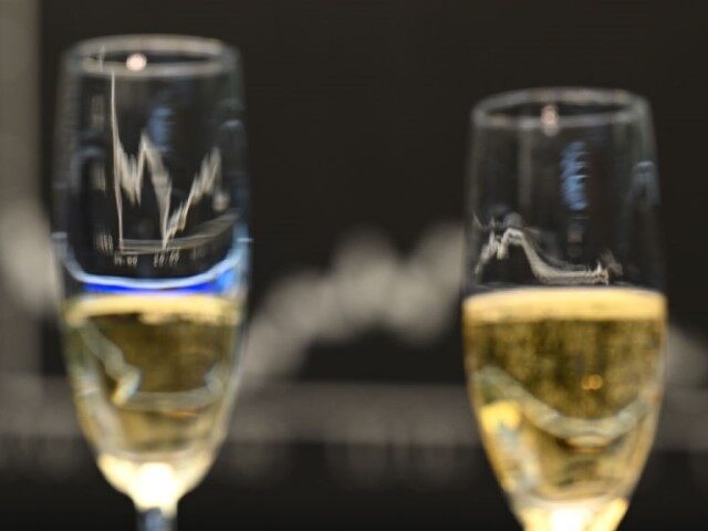 30 December 2022, Hessen, Frankfurt/Main: On the floor of the Frankfurt Stock Exchange, the Dax curve is reflected in two champagne glasses on the shortened last trading day of the year. Photo: Arne Dedert/dpa (Photo by Arne Dedert/picture alliance via Getty Images)