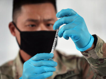 NORTH MIAMI, FLORIDA - MARCH 09: A U.S. Army soldier from the 2nd Armored Brigade Combat Team, 1st Infantry Division, prepares Pfizer COVID-19 vaccines to inoculate people at the Miami Dade College North Campus on March 09, 2021 in North Miami, Florida. The soldiers deployed to assist the Federal Emergency …