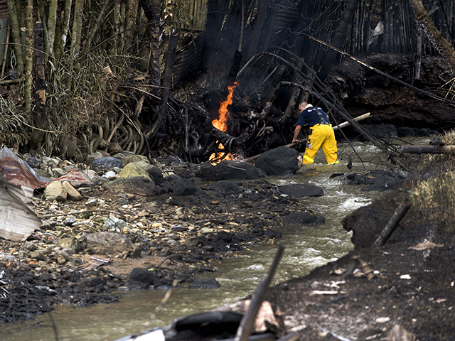 A firefighter tries to put out a fire on the banks of the Agua Azul river that caught fire