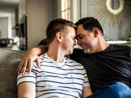 Gay couple embracing on couch