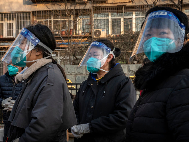 BEIJING, CHINA - DECEMBER 09: Women wear masks and face shields in an area that was recently closed due to COVID-19 cases but has now reopened, on December 9, 2022 in Beijing, China.  In a major shift in the country's zero Covid policy, the Chinese government announced on Wednesday that people infected with Covid-19 with mild or no symptoms will be allowed to quarantine at home instead of a government facility, and will be allowed to buy medicines without a prescription.  Testing requirements will be reduced.  As part of the 10-point directive, local officials can also no longer lock down entire neighborhoods or cities.  (Photo by Kevin Fryer/Getty Images)