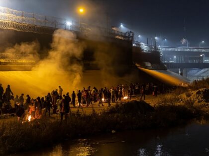 Migrants huddle around makeshift campfires along the Rio Grande in El Paso as temperatures