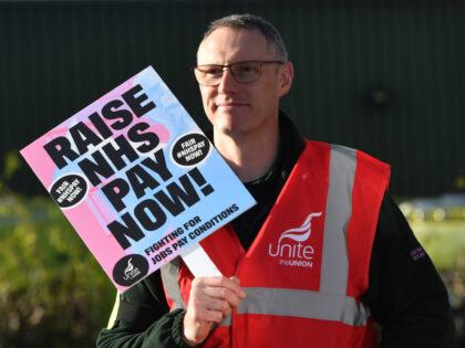 MANCHESTER, ENGLAND - DECEMBER 21: A demonstrator holds a placard on a picket line at Manc