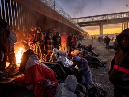 Immigrants warm to a fire at dawn after spending the night outside next to the U.S.-Mexico border fence on December 22, 2022 in El Paso, Texas. A spike in the number of migrants seeking asylum in the United States has challenged local, state and federal authorities. The numbers are expected …