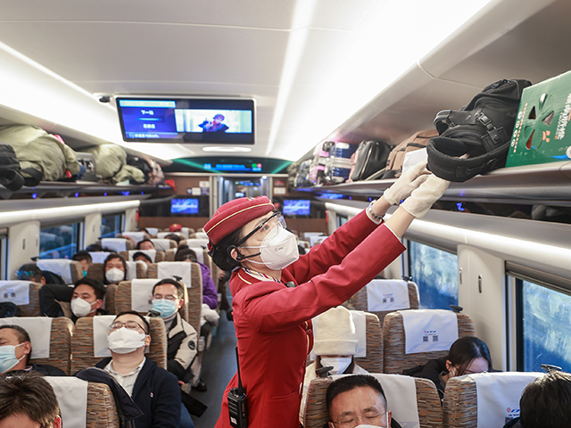 A stewardess arranges suitcases on a high-speed train from Beijing to Nanchang on December 26, 2022 in Beijing, China. A total of 1.69 billion passenger trips have been made on the Beijing-Guangzhou high-speed railway since it went into operation ten years ago. (Photo by Jia Tianyong/China News Service/VCG via Getty …