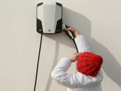 BERLIN, GERMANY - MARCH 15: A child lifts the handle of an electric automobile charger at