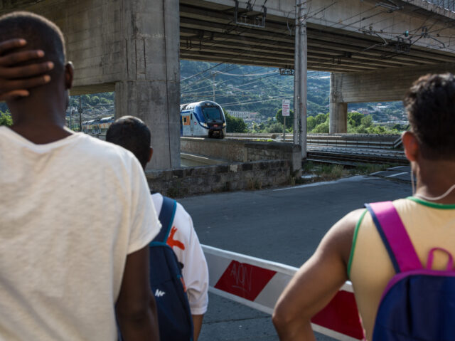 VENTIMIGLIA, ITALY - JUNE 25, 2018: Migrants look at a train that connects Italy with Fran