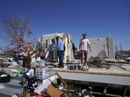Jason Dickenson, left, who survived with his 5 year old son by taking shelter in a bathtub, looks at his destroyed home with his nephew Mayson Bilet, after a tornado struck the area Tuesday night, in Arabi, La., Wednesday, March 23, 2022. (Gerald Herbert/AP)