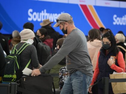 Passengers queue up to check in at the counter for Southwest Airlines Monday, Jan. 3, 2022, in the main terminal of Denver International Airport in Denver. (David Zalubowski/AP)