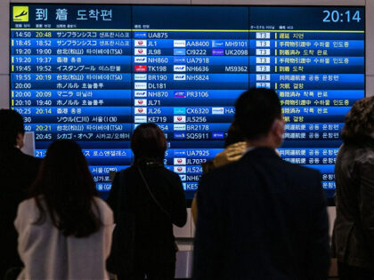 People wait in front a board showing international flight arrivals at Tokyo's Haneda international airport on December 28, 2022. - Hong Kong authorities on December 28 asked Japan to remove restrictions on direct flights from the city, which were imposed following the explosion of coronavirus cases in mainland China. (Photo …