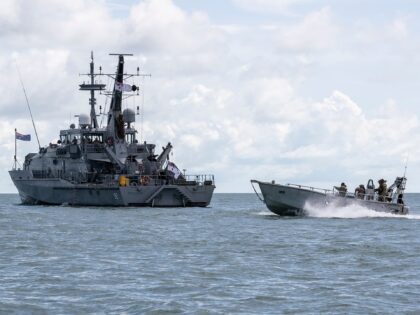 SAIBAI ISLAND, AUSTRALIA - MARCH 26: The HMAS Wollongong is passed by a boat with Australian Denence Force members onboard on March 26, 2021 in Saibai Island, Australia. Australian Border Force and Defence Force personnel are currently patrolling waters in the northern department of Torres Strait as part of Maritime …