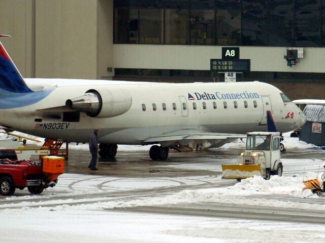 HEBRON, KY - DECEMBER 26: Airline workers clean up snow and ice near a Comair plane at Cin