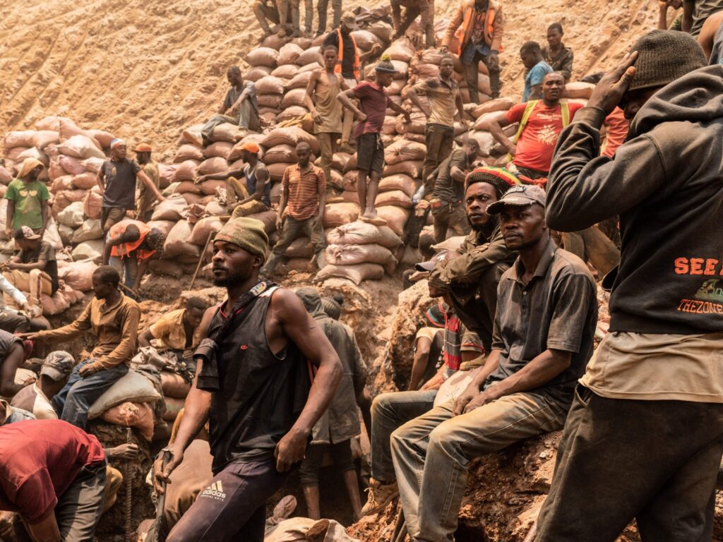 Artisanal miners sit at the Shabara artisanal mine near Kolwezi on October 12, 2022. - Some 20,000 people work at Shabara, in shifts of 5,000 at a time. Congo produced 72 percent of the worlds cobalt last year, according to Darton Commodities. And demand for the metal is exploding due to its use in the rechargeable batteries that power mobile phones and electric cars. But the countrys poorly regulated artisanal mines, which produce a small but not-negligeable percentage of its total output, have tarnished the image of Congolese cobalt. (Photo by Junior KANNAH / AFP) (Photo by JUNIOR KANNAH/AFP via Getty Images)