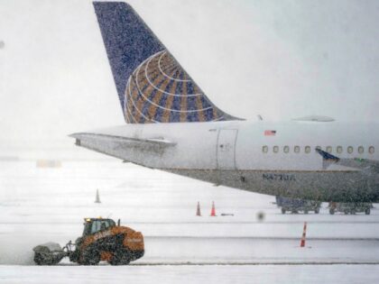 Snow and ice are cleared outside a parked plane at Dallas Fort Worth International Airport in Grapevine, Texas, Thursday, Feb. 3, 2022. A major winter storm with millions of Americans in its path is spreading rain, freezing rain and heavy snow further across the country. (AP Photo/LM Otero)