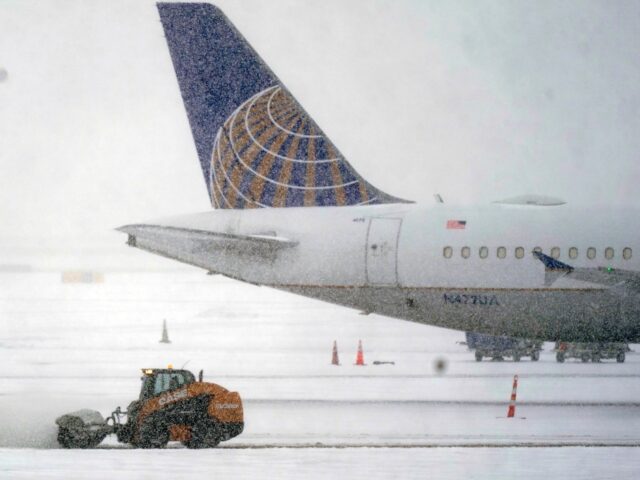 Snow and ice are cleared outside a parked plane at Dallas Fort Worth International Airport