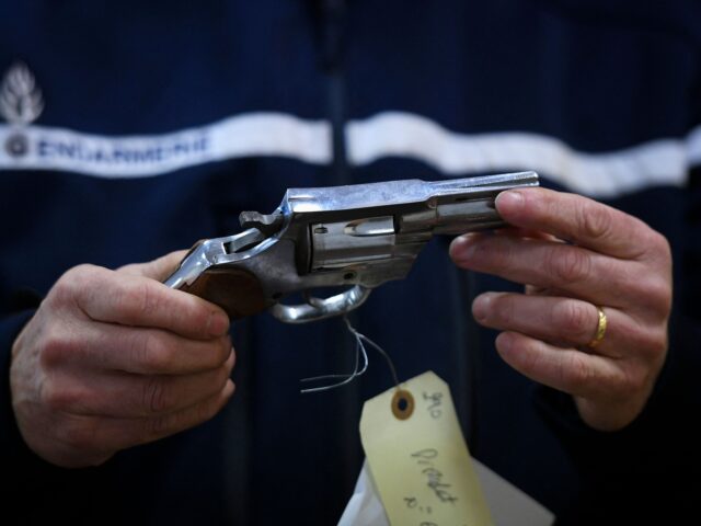 A French gendarme holds a tagged firearm collected in the former school of Lapeyriere in Lisle-sur-Tarn, south-western France, on November 28, 2022. - From November 25 to December 2, 2022 private individuals, undeclared holders of weapons found or acquired by inheritance, can go to specially opened sites throughout French territory …