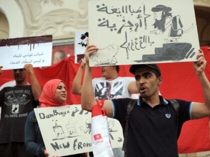 A Tunisian protester holds up a placards reading in Arabic : "Allegiance or tax levy (Jizya in Arabic)" during a demonstration against the Islamic State (IS) group on September 25, 2014 in the capital Tunis. The IS group has seized large parts of Iraq and Syria, declaring a Muslim "caliphate" …
