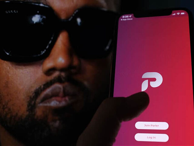 This illustration photo shows the Parler social network app logo on a cell phone screen with a picture of US rapper Kanye West in the background in Los Angeles, October 17, 2022. - Social network Parler announced on October 17 a deal for Kanye West to buy the platform popular …