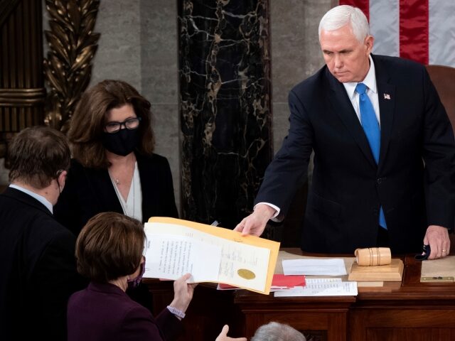 FILE - Vice President Mike Pence hands the electoral certificate from the state of Arizona to Sen. Amy Klobuchar, D-Minn., as he presides over a joint session of Congress as it convenes to count the Electoral College votes cast in November's election, at the Capitol in Washington, Jan. 6, 2021. …