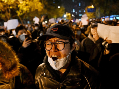 Protesters march along a street during a rally for the victims of a deadly fire as well as a protest against China's harsh Covid-19 restrictions in Beijing on November 28, 2022. - A deadly fire on November 24, 2022 in Urumqi, the capital of northwest China's Xinjiang region, has become …