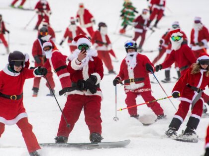 Three hundred plus skiers and snowboarders dressed as Santa Clause, and some other holiday characters, take off from the top of the mountain as they take part in the Santa Sunday event at Sunday River Resort in Newry, Maine on December 11, 2022. Money raised by the the event goes …