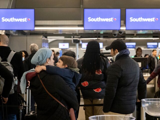 Passengers wait in line to check in for their flights at Southwest Airlines service desk at LaGuardia Airport, Tuesday, Dec. 27, 2022, in New York. The U.S. Department of Transportation says it will look into flight cancellations by Southwest that have left travelers stranded at airports across the country amid …