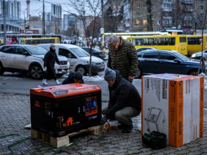 FILE -Ukrainians unpack a power generator before installing it at a bank branch in Kyiv, Ukraine, on Dec. 1, 2022. When Russian forces two months ago launched a military campaign against infrastructure in Ukraine, it opened an urgent second front far from the contact line: along power lines, water mains, …