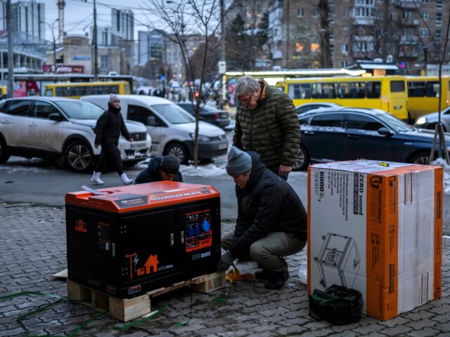 FILE -Ukrainians unpack a power generator before installing it at a bank branch in Kyiv, U