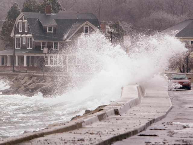 A wave breaks over a sea wall near a car on Beach Avenue in Kennebunk on Tuesday, December 9, 2014. The storm passing through the state caused some minor coastal flooding during high tide on Tuesday. (Photo by Gregory Rec/Portland Portland Press Herald via Getty Images)