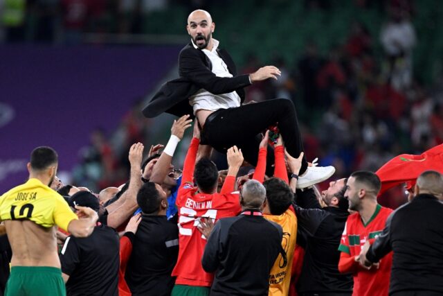 Morocco coach Walid Regragui is hoisted aloft by his players after they beat Portugal to r