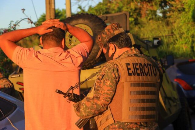 A Salvadoran soldier searches a man during a major government operation against gangs in t
