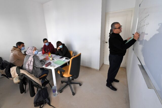 Tunisian Yeft Benazzouz (R), who runs a language school in the capital Tunis, teaches a cl