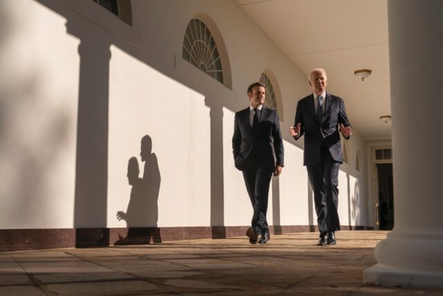 US President Joe Biden and French President Emmanuel Macron walk down the Colonnade at the