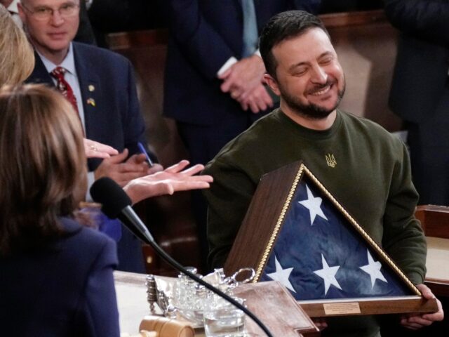 Ukrainian President Volodymyr Zelenskyy holds an American flag that was gifted to him by H