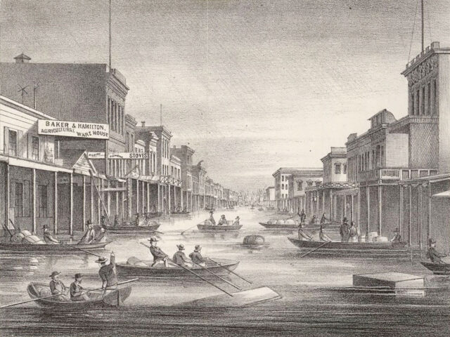 J street in downtown Sacramento seen from levee showing flood of 1862; people in boats mak