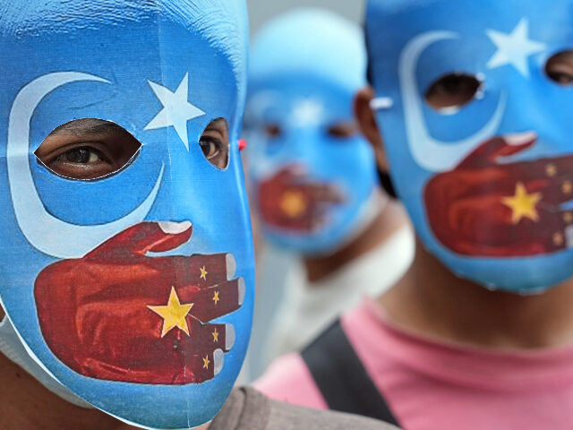 Student activists wear masks with the colors of the pro-independence East Turkistan flag d