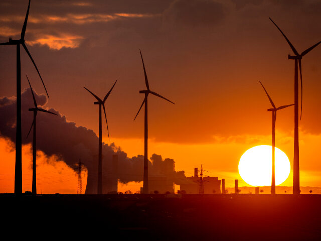 FILE - Steam rises from the coal-fired power plant near wind turbines in Niederaussem, Ger
