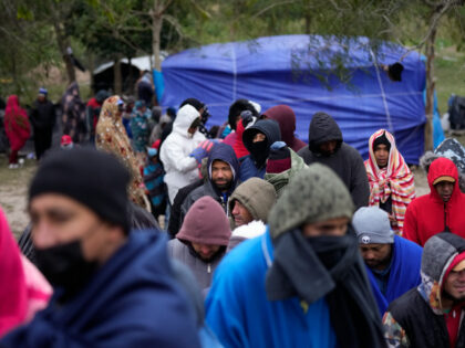 FILE - Migrants from Venezuela line up in the cold weather for hot drinks and food from volunteers at a makeshift camp on the U.S.-Mexico Border in Matamoros, Mexico, Dec. 23, 2022. The Supreme Court is keeping pandemic-era limits on people seeking asylum in place indefinitely, dashing hopes of immigration …