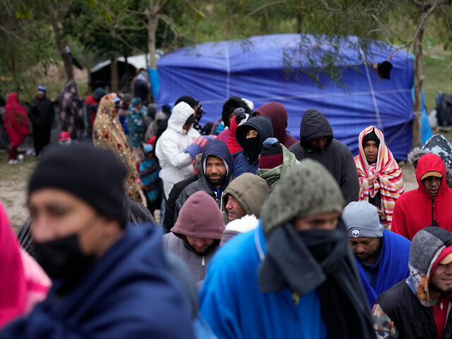 FILE - Migrants from Venezuela line up in the cold weather for hot drinks and food from vo