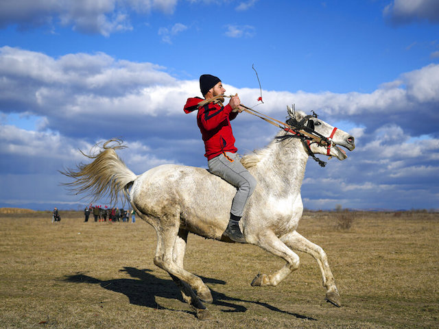 A man rides a horse during Epiphany celebrations in the village of Pietrosani, Romania, Friday, Jan. 6, 2023. According to the local Epiphany traditions, following a religious service, villagers have their horses blessed with holy water and then compete in a race. (AP Photo/Vadim Ghirda)