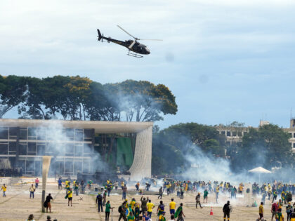 Protesters, supporters of Brazil's former President Jair Bolsonaro, clash with police as they storm the Planalto Palace in Brasilia, Brazil, Sunday, Jan. 8, 2023. Planalto is the official workplace of the president of Brazil. (AP Photo/Eraldo Peres)