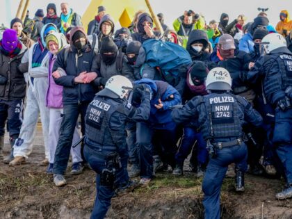 Police officers and protesters clash on a road at the village Luetzerath near Erkelenz, Germany, Tuesday, Jan. 10, 2023. The village of Luetzerath is occupied by climate activists fighting against the demolishing of the village to expand the Garzweiler lignite coal mine near the Dutch border. (AP Photo/Michael Probst)